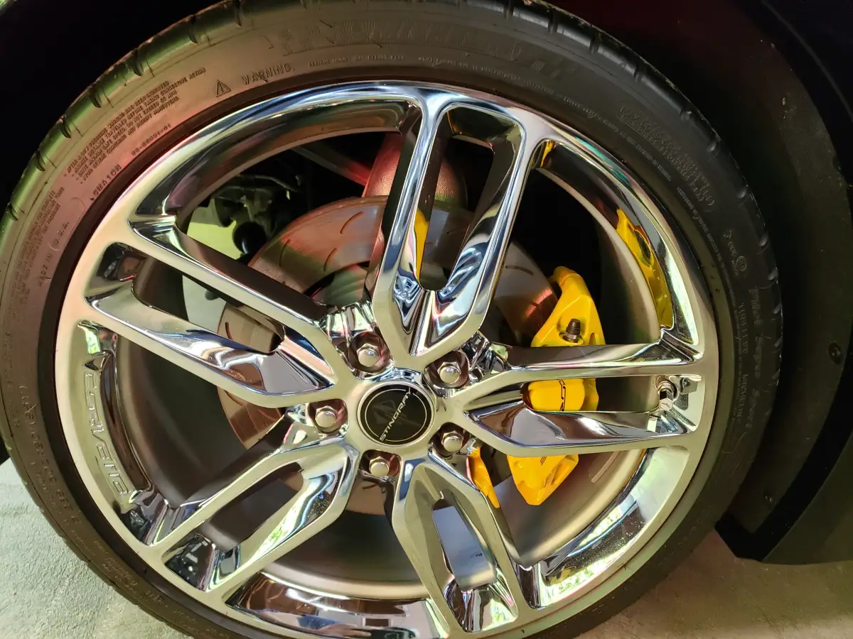 Detail shot of a chrome Corvette Stingray wheel and rotor with yellow brake caliper