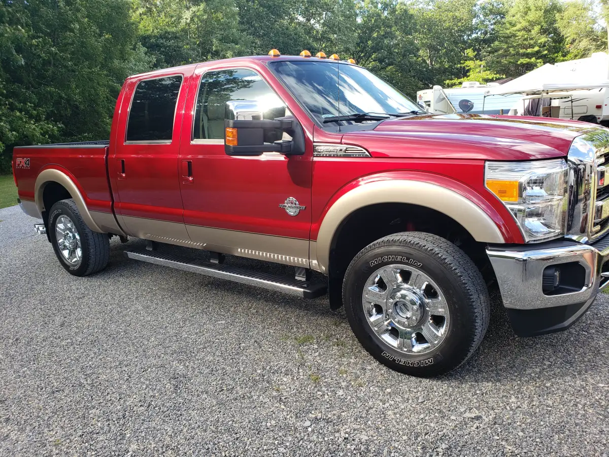 Red Ford F-250 Super Duty pickup truck freshly detailed on a gravel driveway