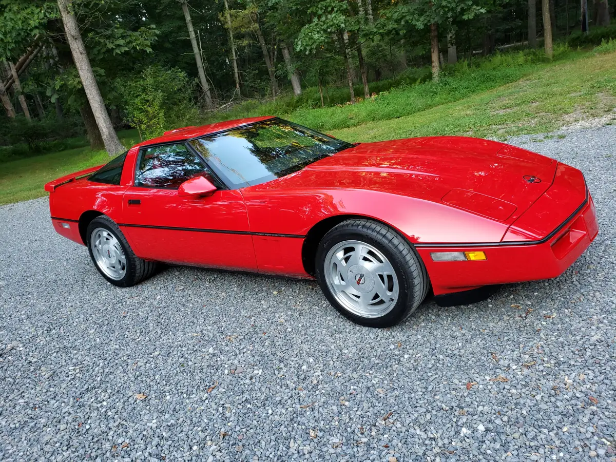 Red C4 Corvette front side view with high-gloss ceramic coated paint on gravel driveway