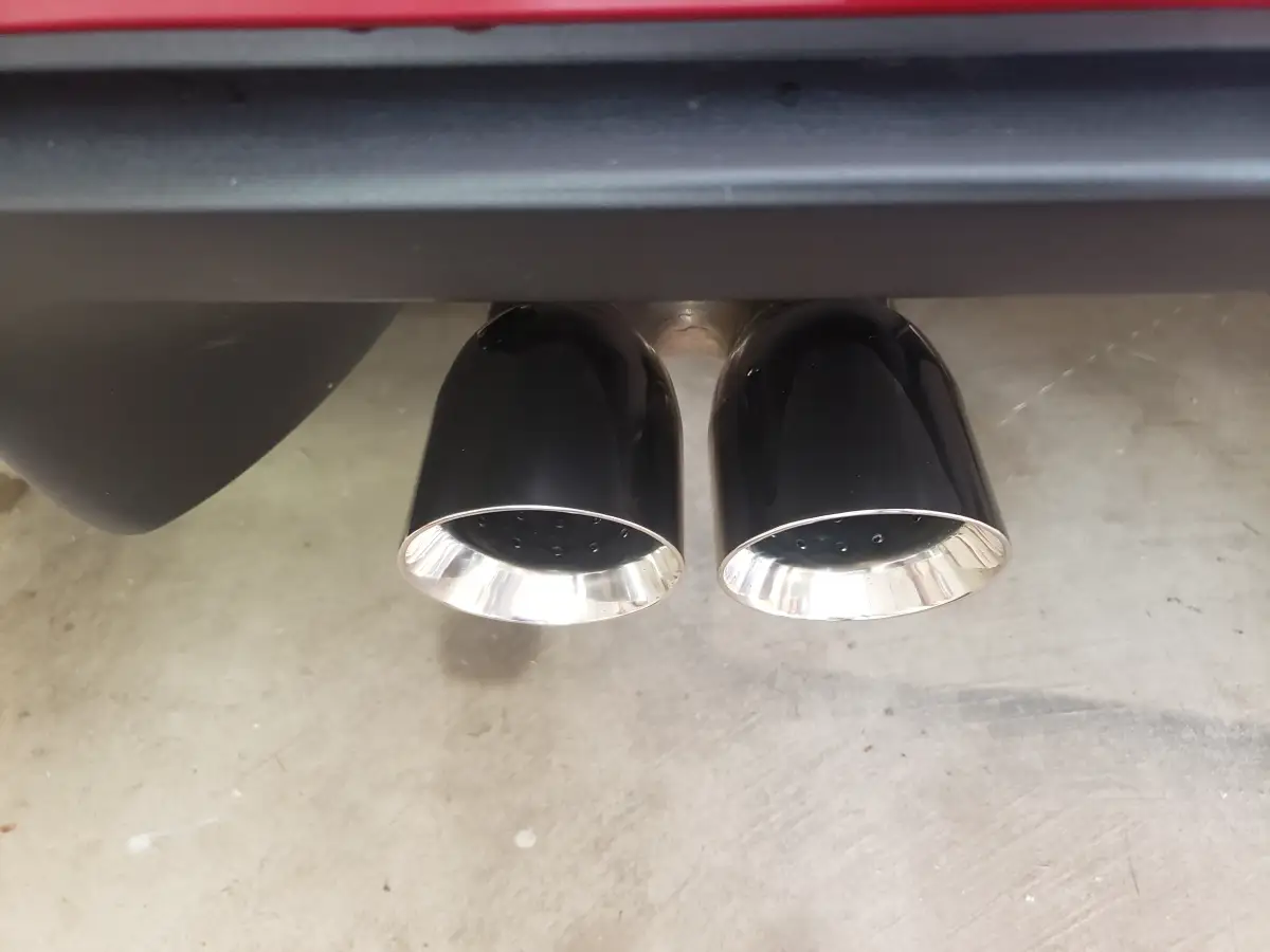 Close-up of black and chrome dual exhaust tips after detailing