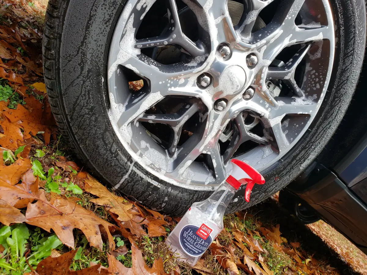 Dark blue Jeep Grand Cherokee parked on gravel in front of wooded background