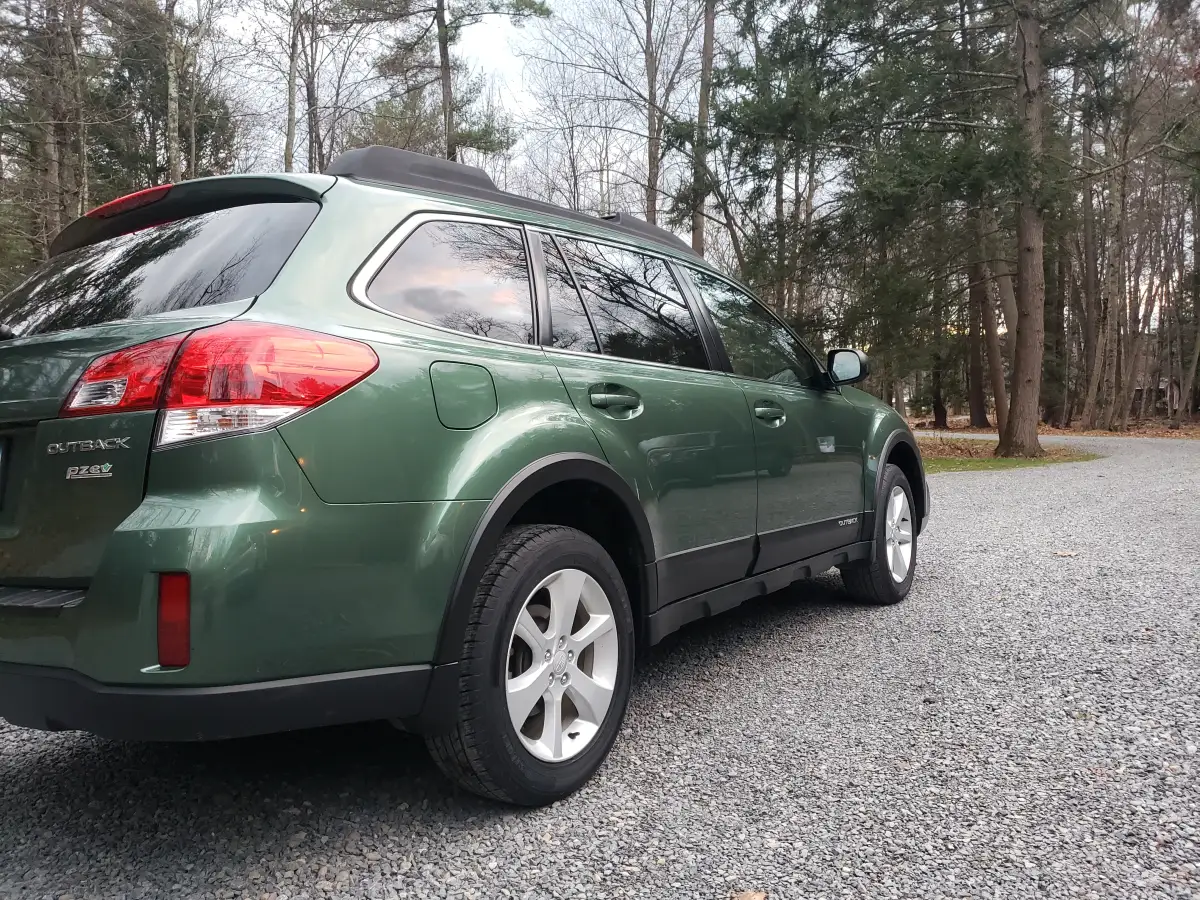 Green Subaru Outback rear side view showing glossy detailed exterior finish
