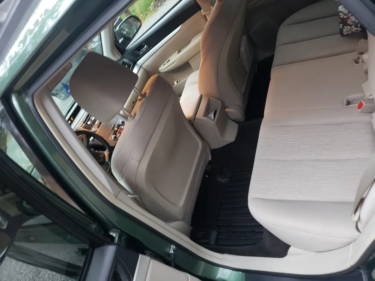 Clean tan leather interior of a Subaru Outback showing front and rear seats