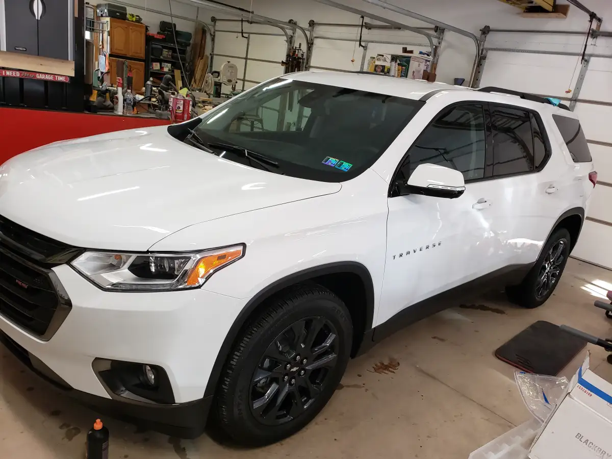 Freshly detailed white Chevrolet Traverse SUV parked in a home garage