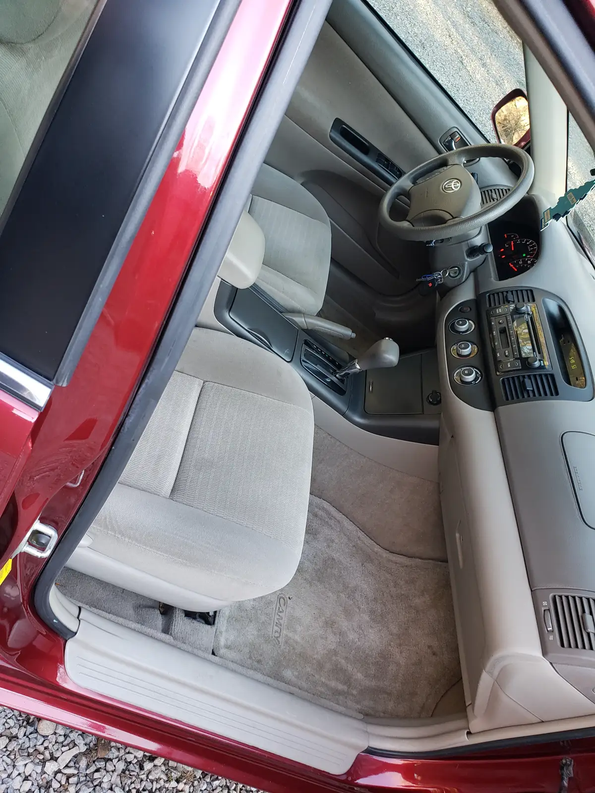 Vacuumed tan cloth seats and carpet inside a detailed Toyota Camry