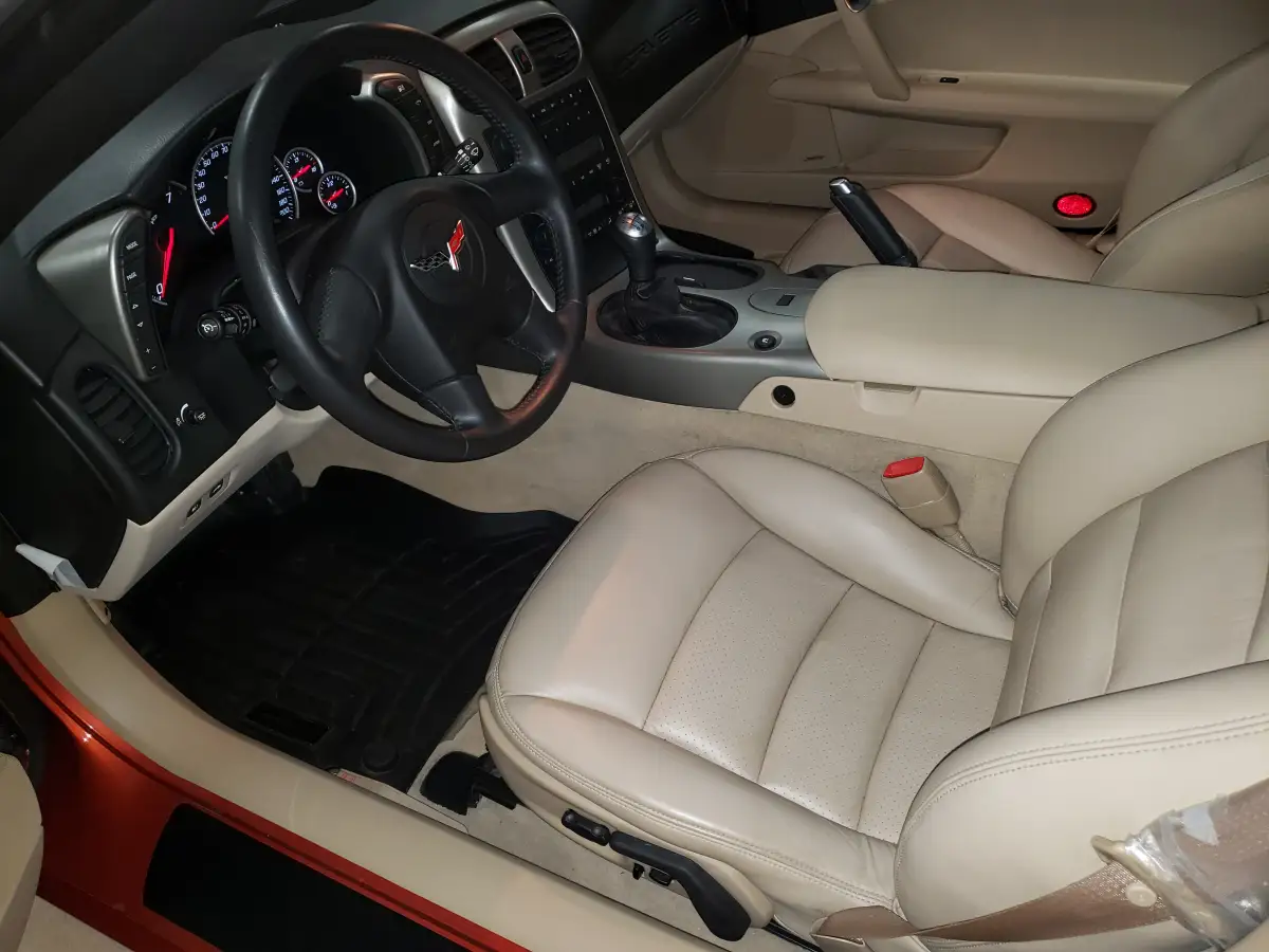 Clean tan leather seats and dashboard inside a detailed Corvette