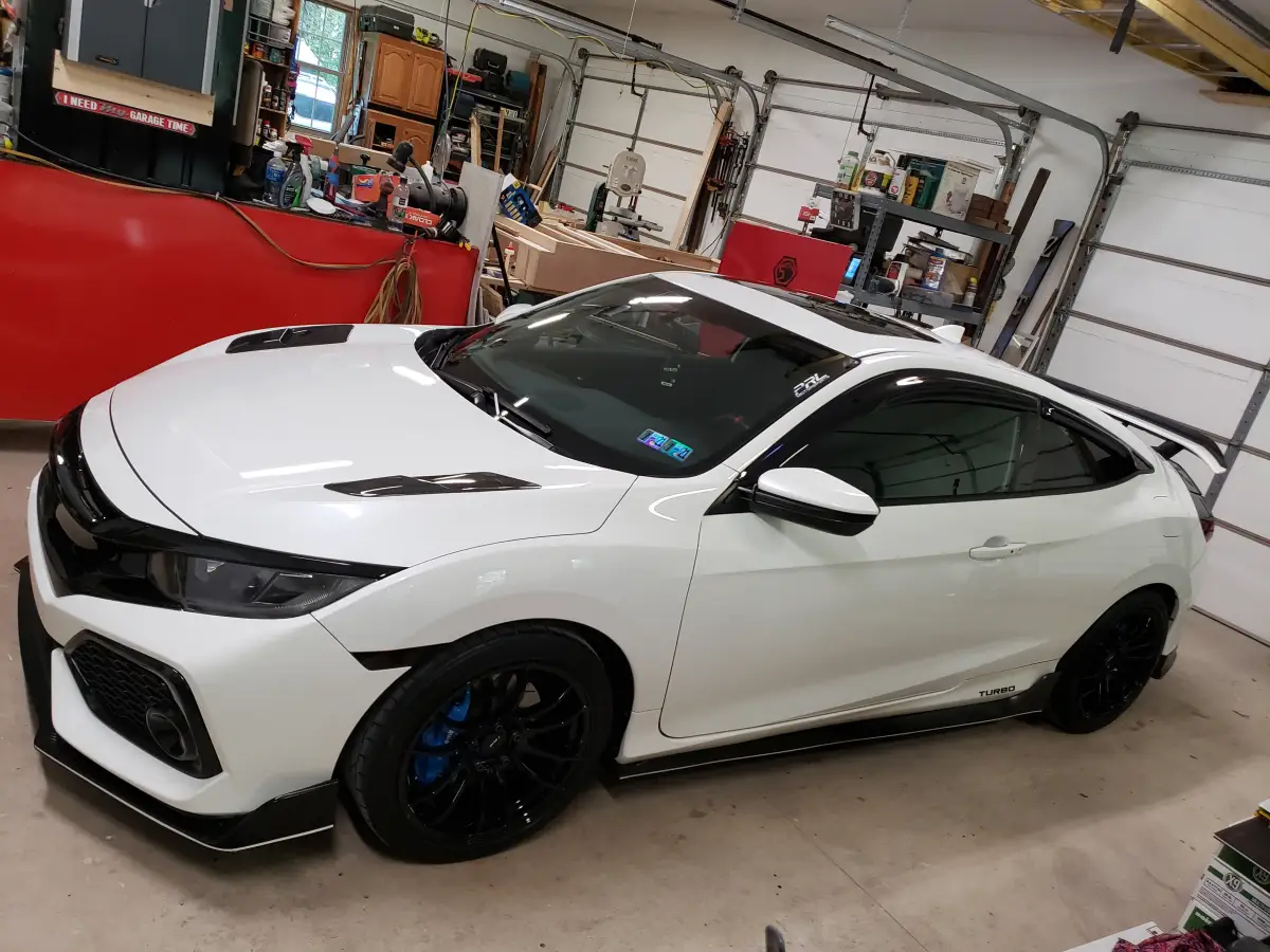Detailed white Honda Civic Type R hatchback with black wheels parked in a garage