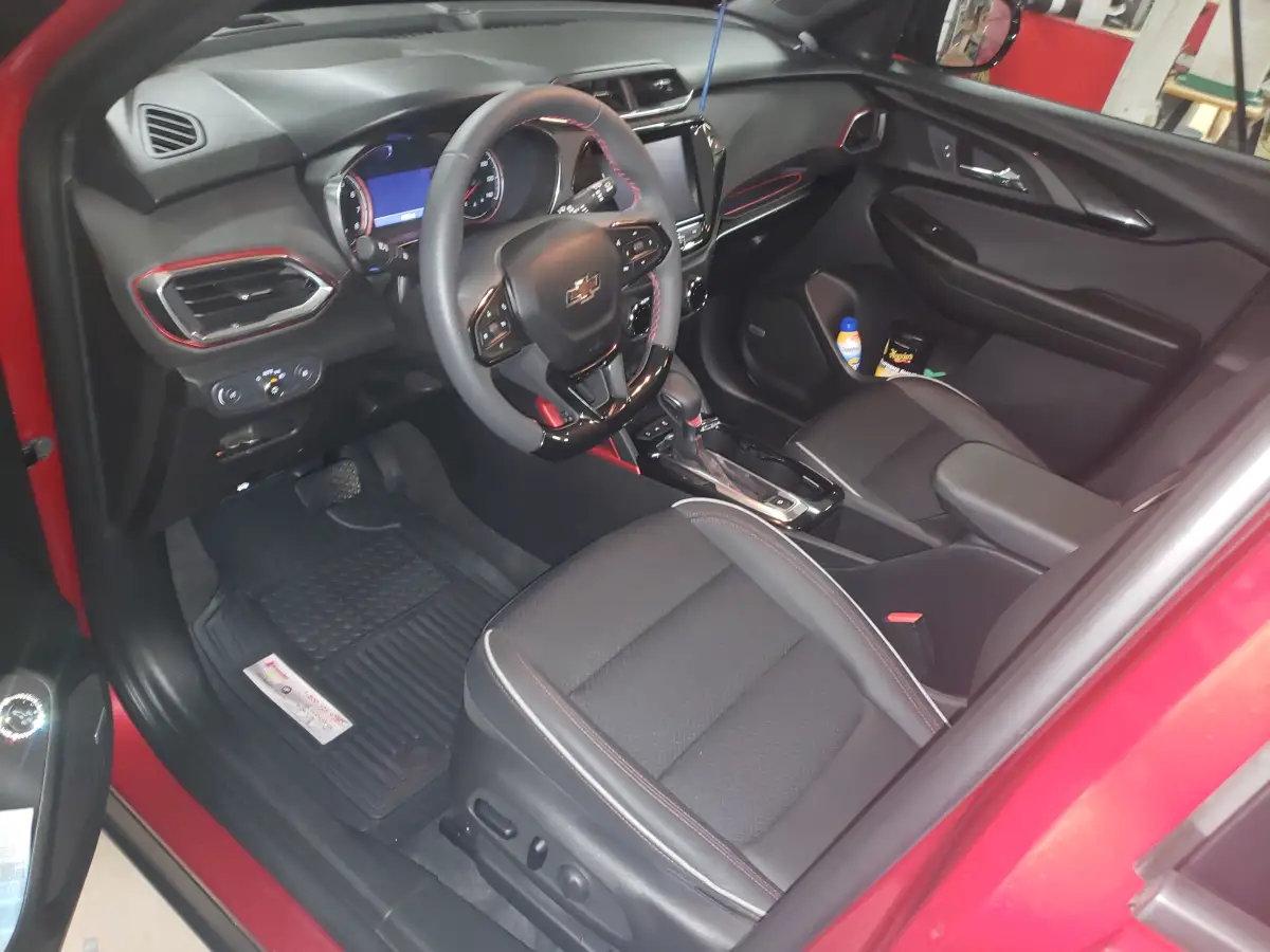 Clean black and red leather dashboard and front seats of a red Chevrolet SUV