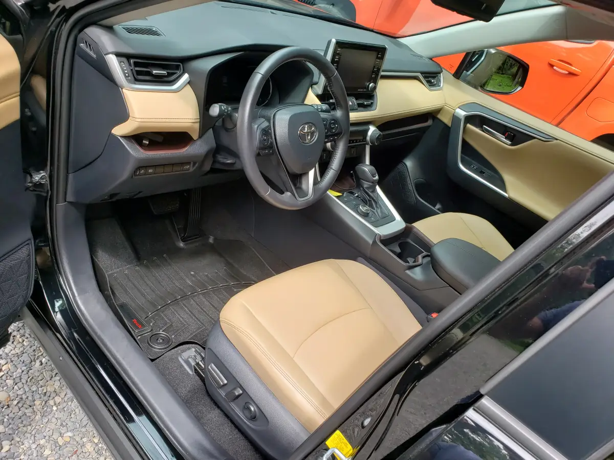 Clean tan leather front seat and dashboard of a black Toyota RAV4