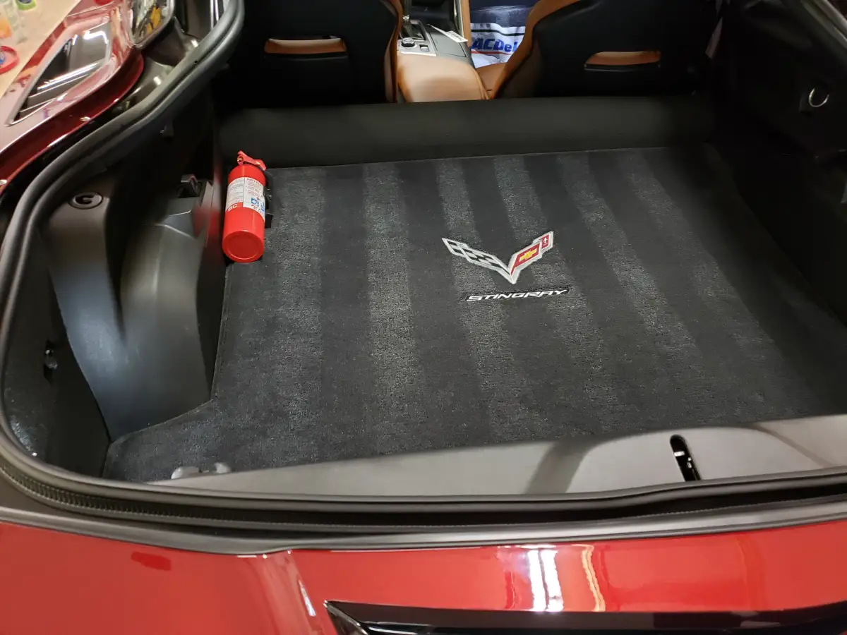 Clean Stingray branded trunk carpet with a fire extinguisher in a red Corvette