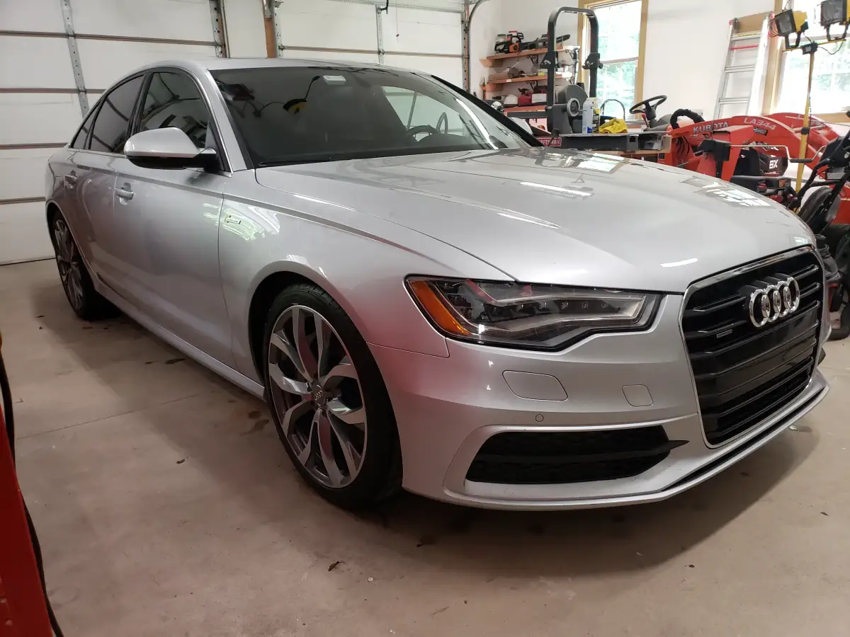 Freshly detailed silver Audi A6 sedan parked in a garage workshop