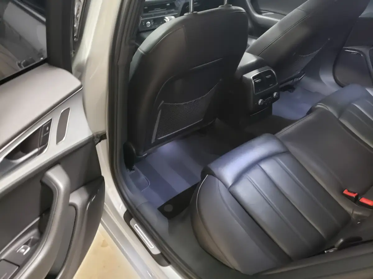 Clean black leather rear seats and floor of a silver Audi sedan