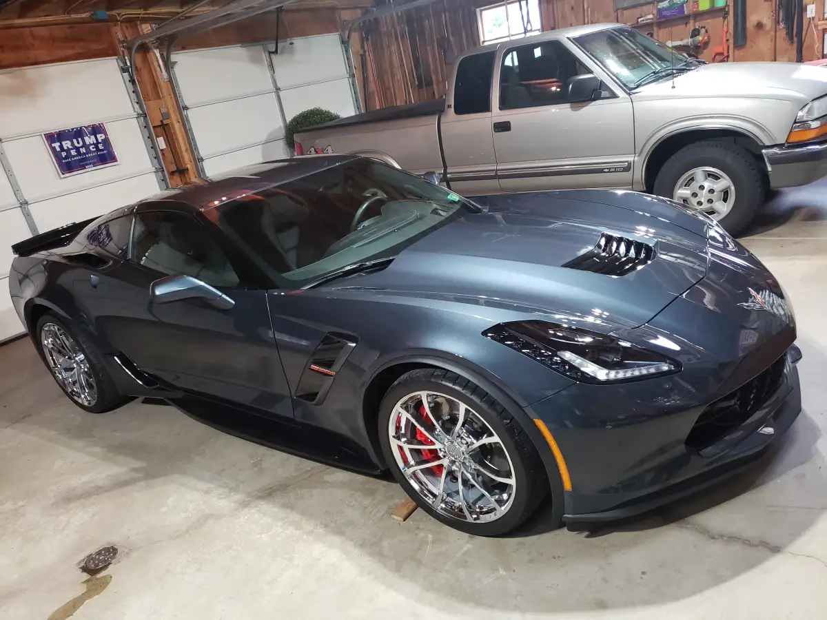 Dark gray Corvette Grand Sport with deep glossy ceramic coated finish parked in a garage