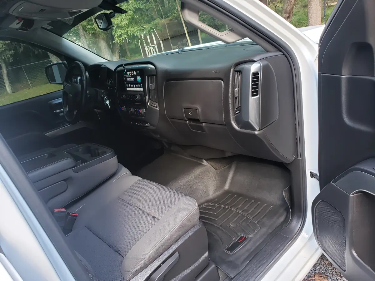 Clean black truck dashboard and passenger footwell after interior detailing