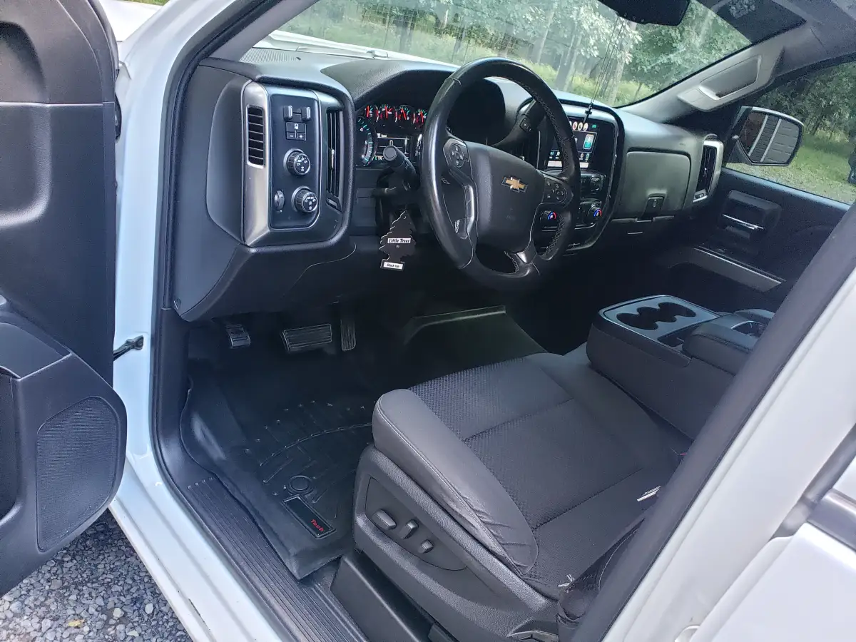Detailed black leather truck cabin interior with dashboard and steering wheel from driver's door