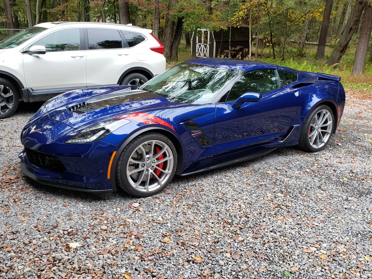 Glossy blue Chevrolet Corvette Grand Sport with deep ceramic coating shine parked outdoors